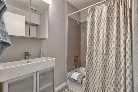 a bathroom with a shower and sink and a shower curtain